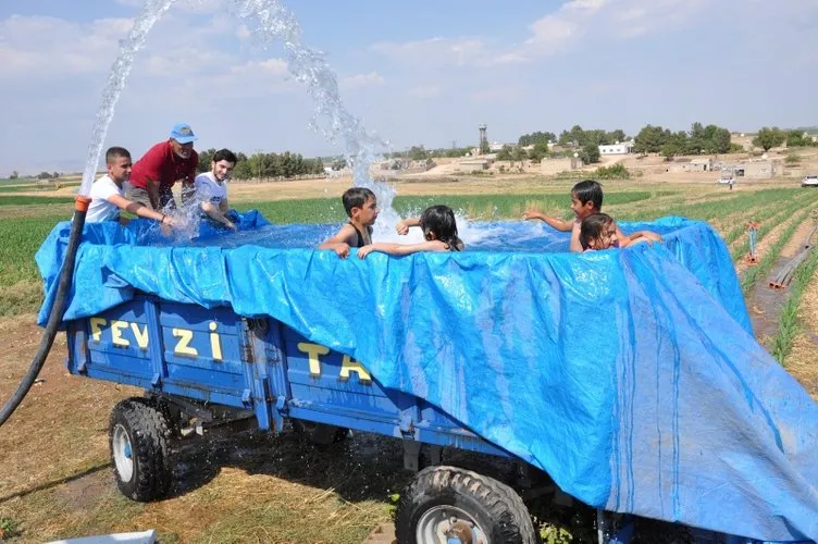Sıcaktan bunalan çiftçiler traktör römorkunu havuza çevirdi