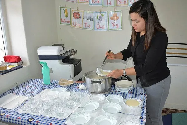 Öğrencilerine odun sobasında puding hazırlıyor