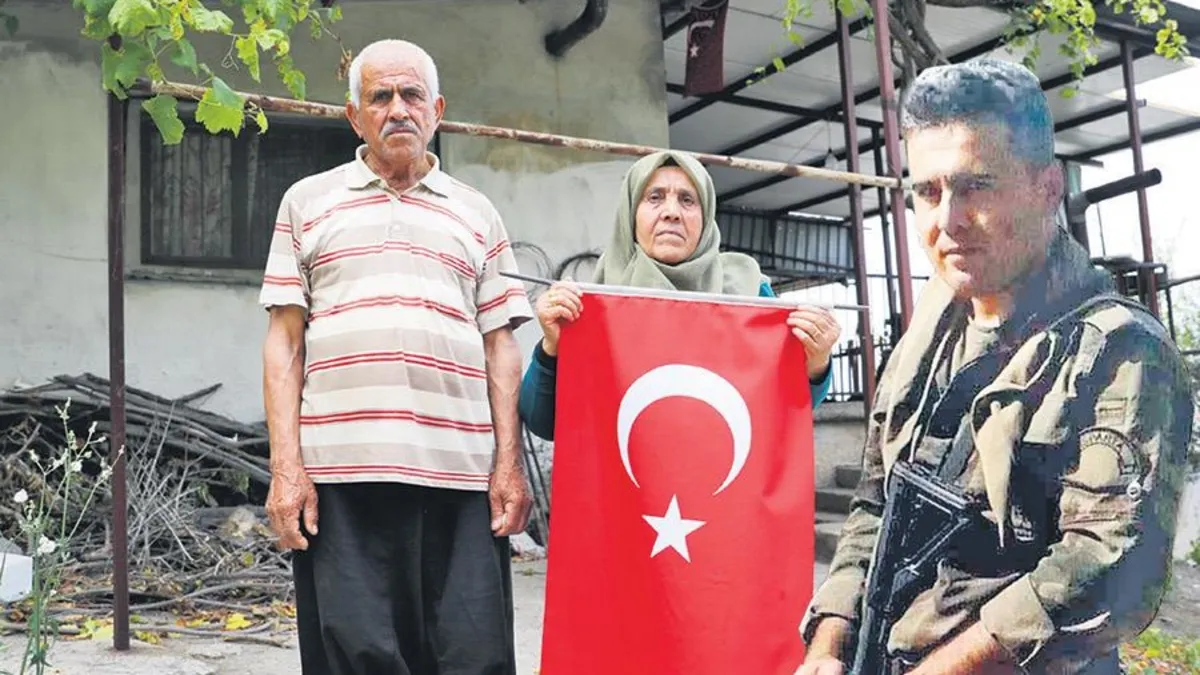 Şehit Polis Mehmet Karacatilki'nin ailesine üzerinde kanı bulunan Türk bayrağı teslim ediliyor.