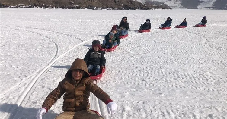 Köy çocukları Çıldır Gölünde kar motoruyla kızak kaydı