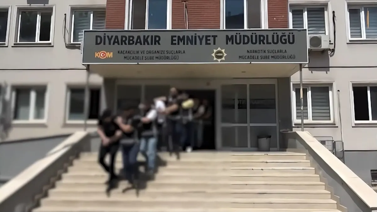 Diyarbakır'da suç örgütüne yönelik operasyon düzenlendiği ve şüphelilerin gözaltına alındığı anı gösteren görsel.