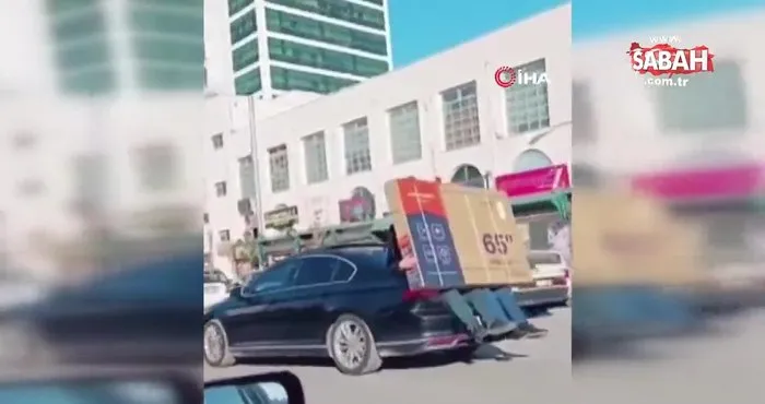 Lüks otomobilin bagajına oturup 65 inç ekran televizyonu böyle taşıdı | Video