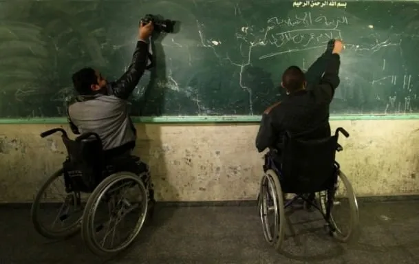 Tekerlekli sandalyesinde öğretmenlik yapıyor