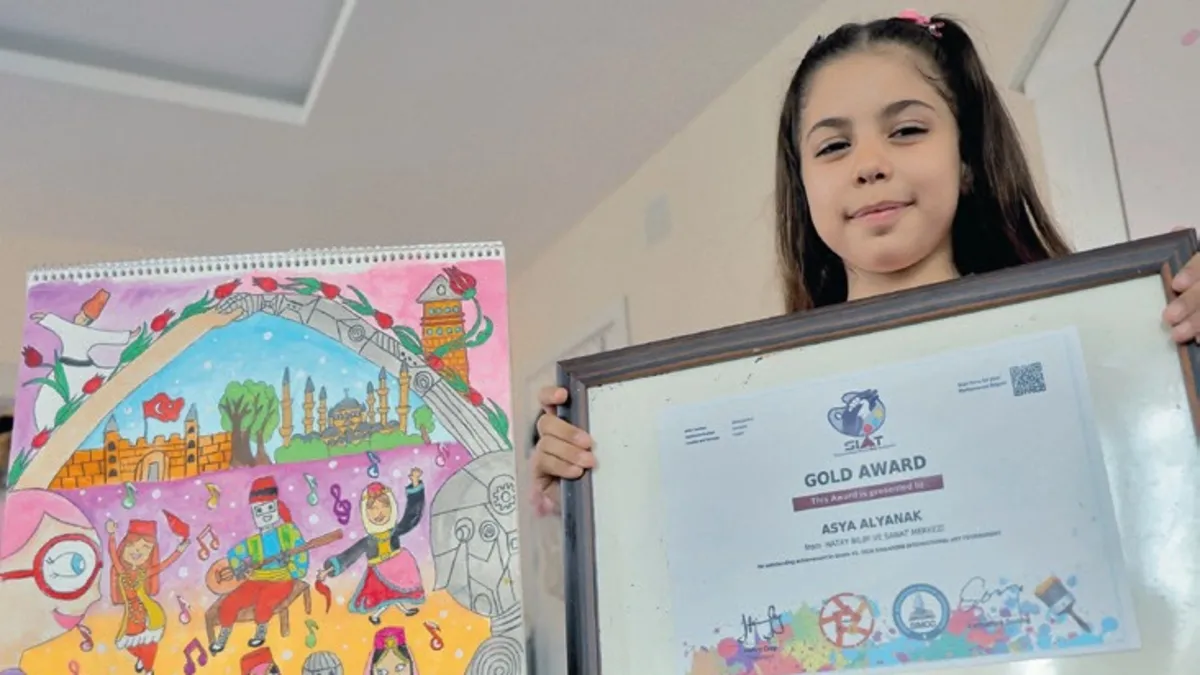8 yaşındaki Asya Alyanak, Uluslararası Singapur Sanat Olimpiyatları'nda birinci olan resmiyle birlikte.