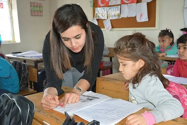 Öğrencilerine odun sobasında puding hazırlıyor
