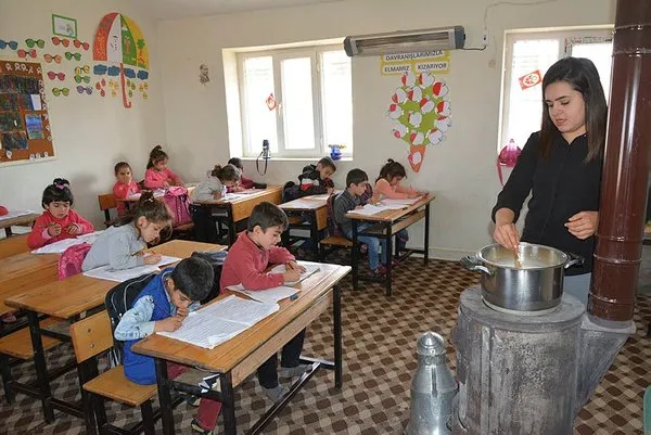 Öğrencilerine odun sobasında puding hazırlıyor