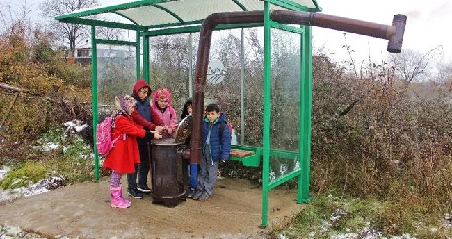 Çocuklar üşümesin diye durağa soba kurdu