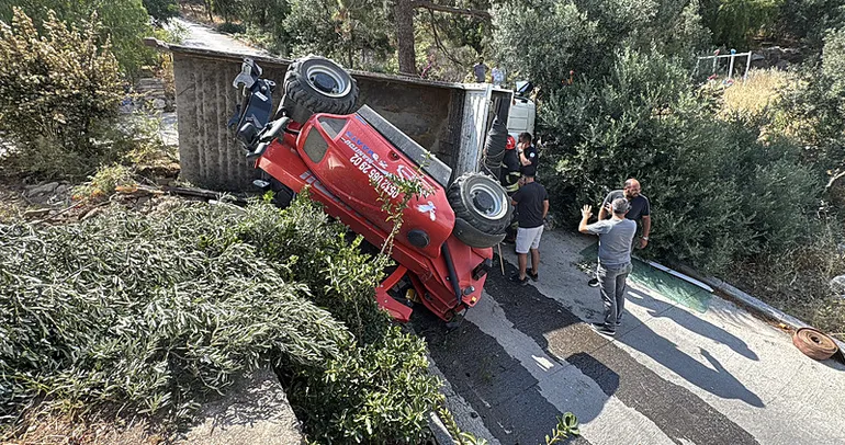 Muğla’da iş makinesi taşıyan kamyon devrildi