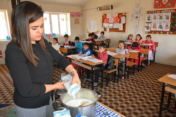 Öğrencilerine odun sobasında puding hazırlıyor