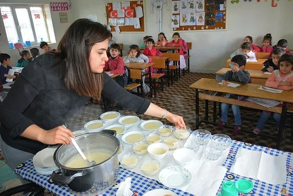 Öğrencilerine odun sobasında puding hazırlıyor