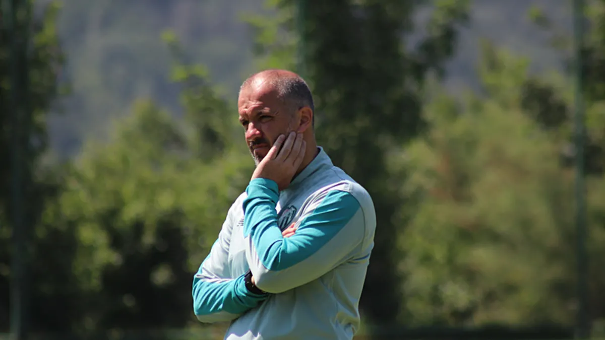 Bursaspor Teknik Direktörü Mustafa Er'in antrenman sahasında oyunculara talimat verirken çekilmiş fotoğrafı.