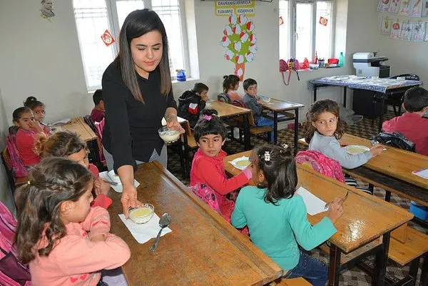 Öğrencilerine odun sobasında puding hazırlıyor