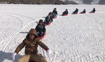 Köy çocukları Çıldır Gölünde kar motoruyla kızak kaydı