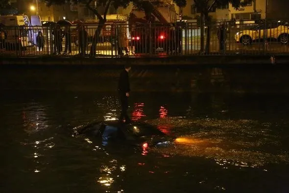 Kanala düşen otomobilin üstüne çıkarak kurtarılmayı bekledi