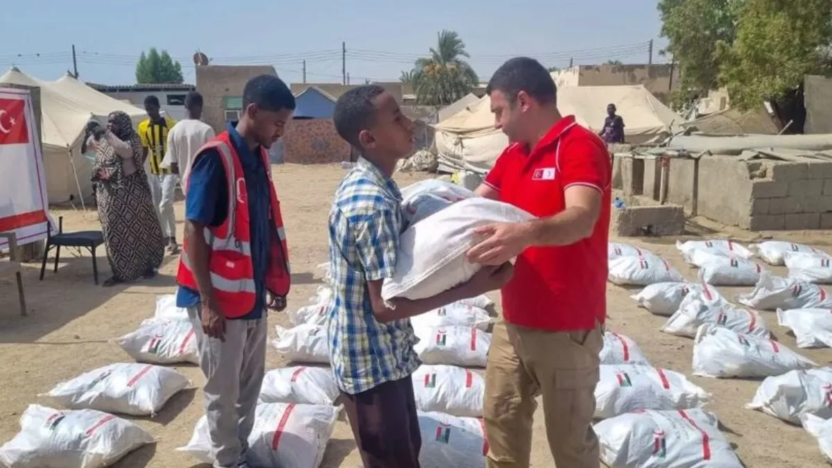 Türk Kızılay görevlileri Sudan'da ihtiyaç sahiplerine gıda kolisi dağıtıyor.