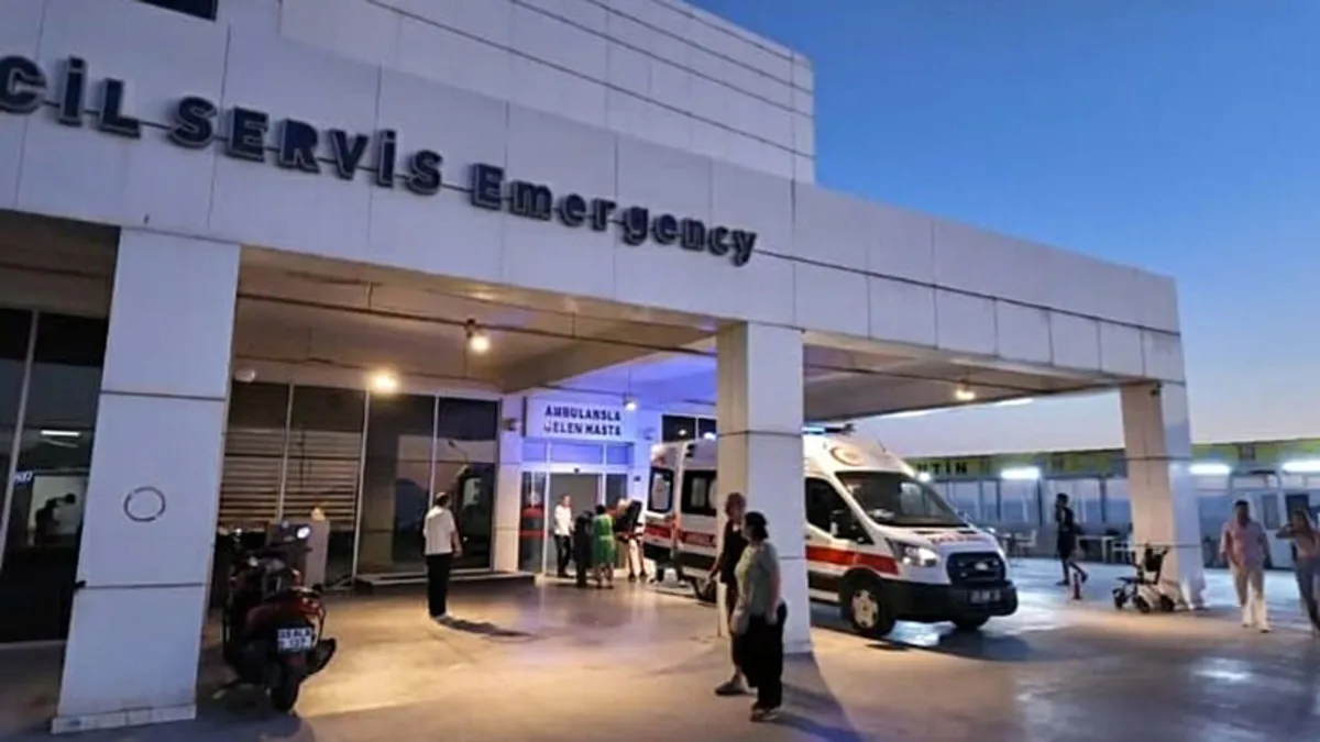 Kuşadası'nda bir otelde gıda zehirlenmesi şüphesiyle hastaneye kaldırılan kişilerin ambulanslarla taşınması.