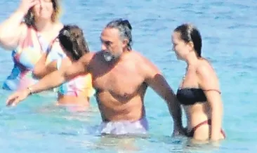 Plajda eşinin elini bırakmadı