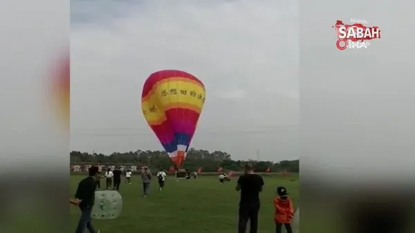 Çinli çalışan sıcak hava balonunun sepetine asılı kalıp metrelerce yüksekten yere çakıldı